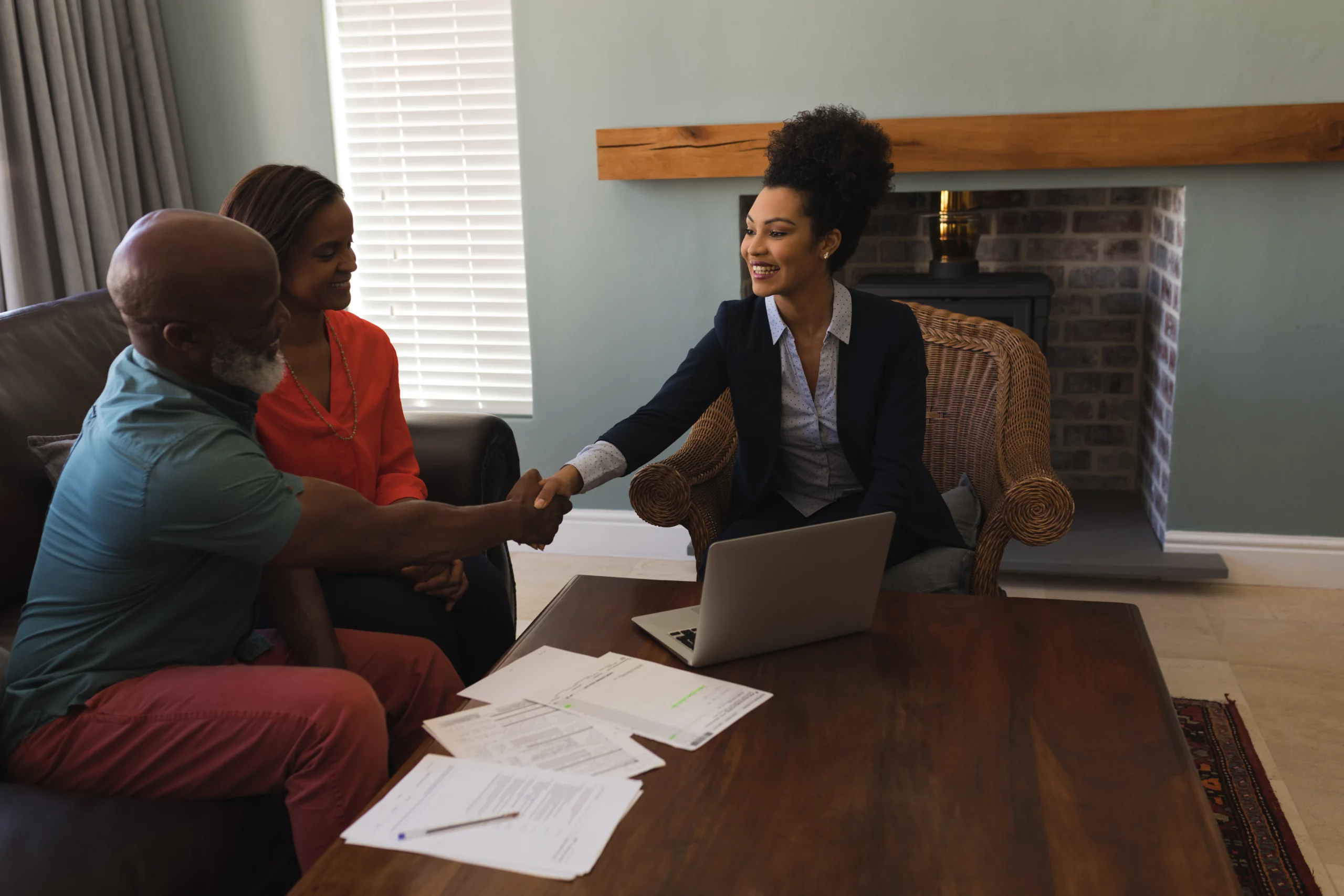Professional woman shaking hands with couple during California estate planning meeting to avoid probate.