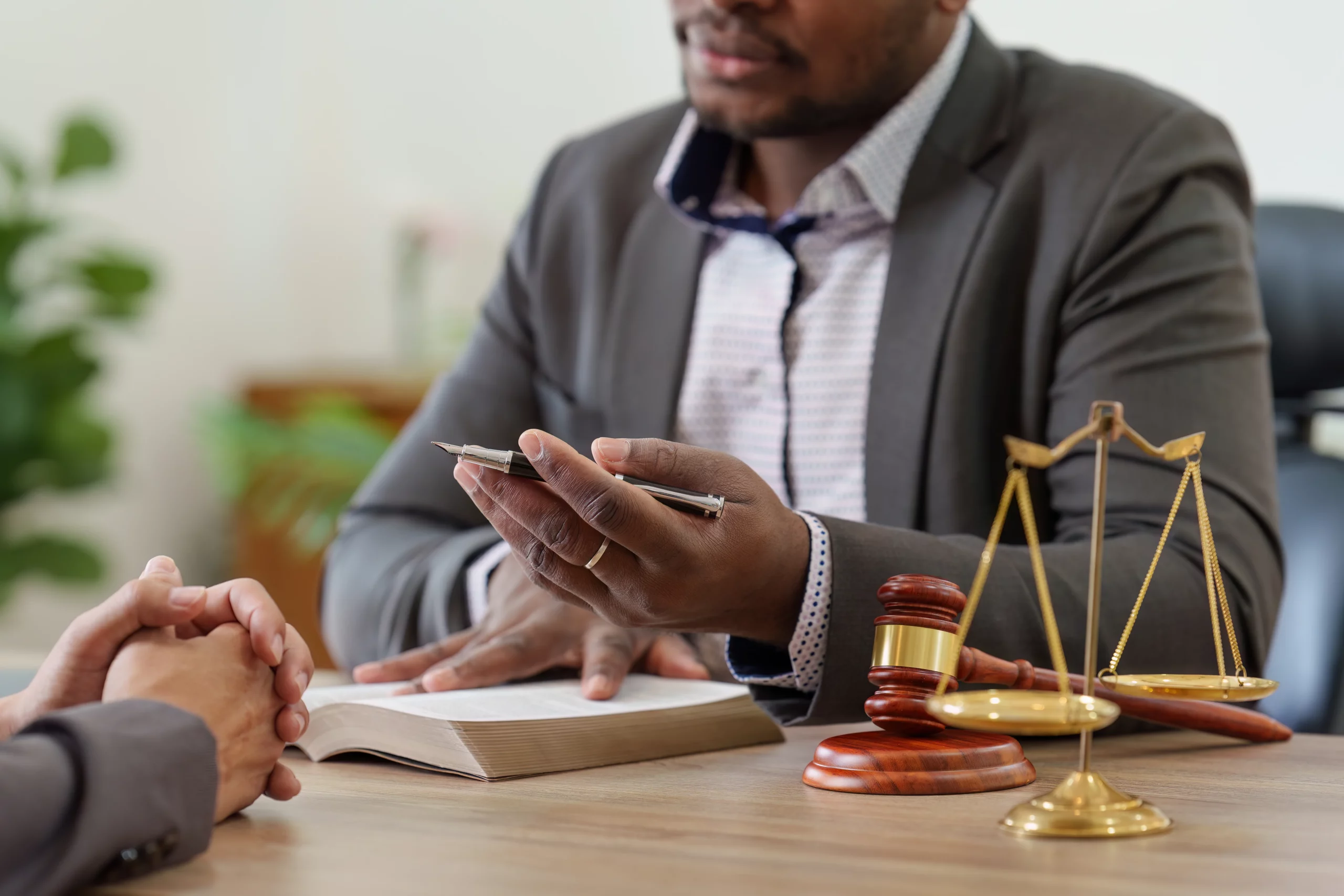 Attorney in suit at desk with gavel, scales of justice, and legal book discussing how to obtain a restraining order in California